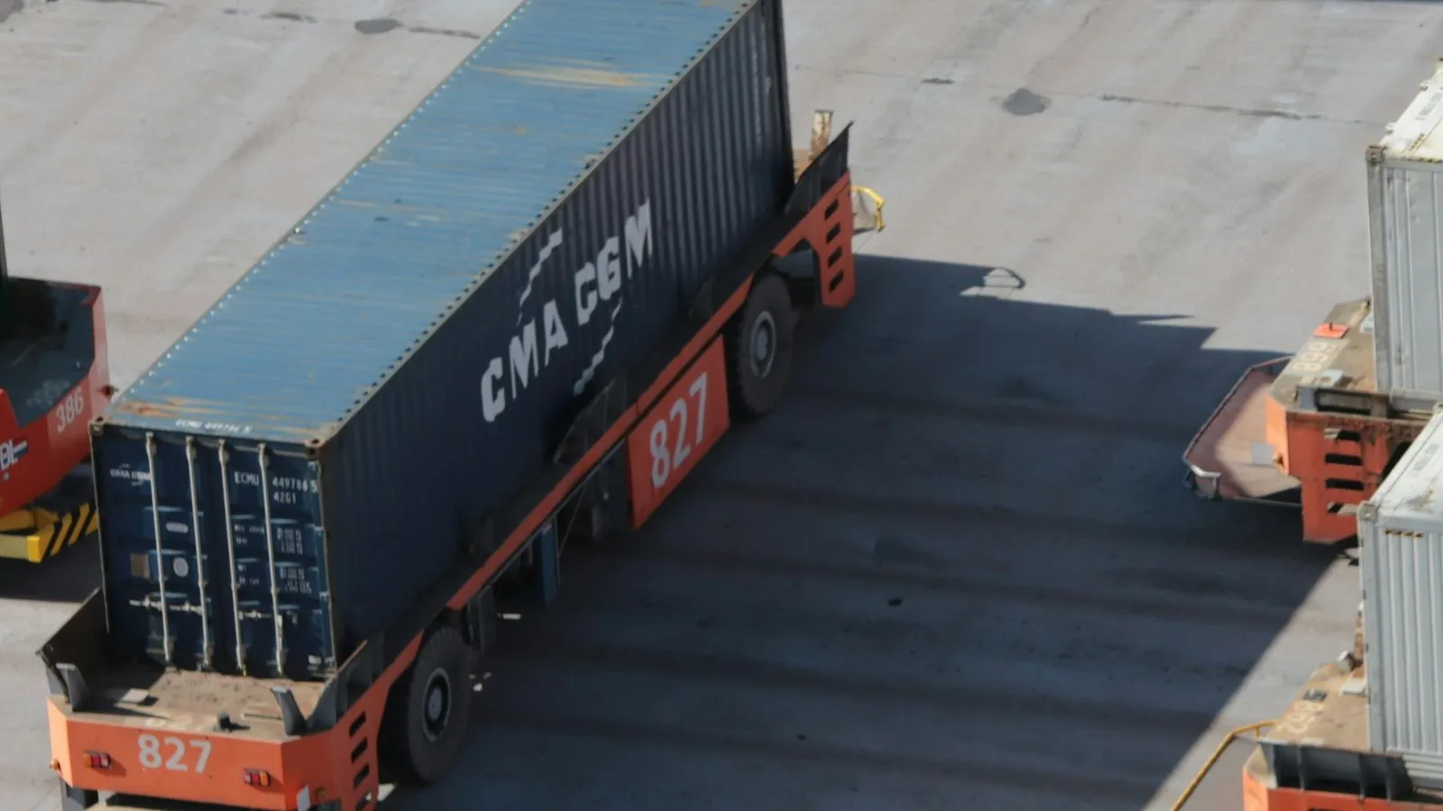 Terminal truck carrying a CMA CGM shipping container across a port yard